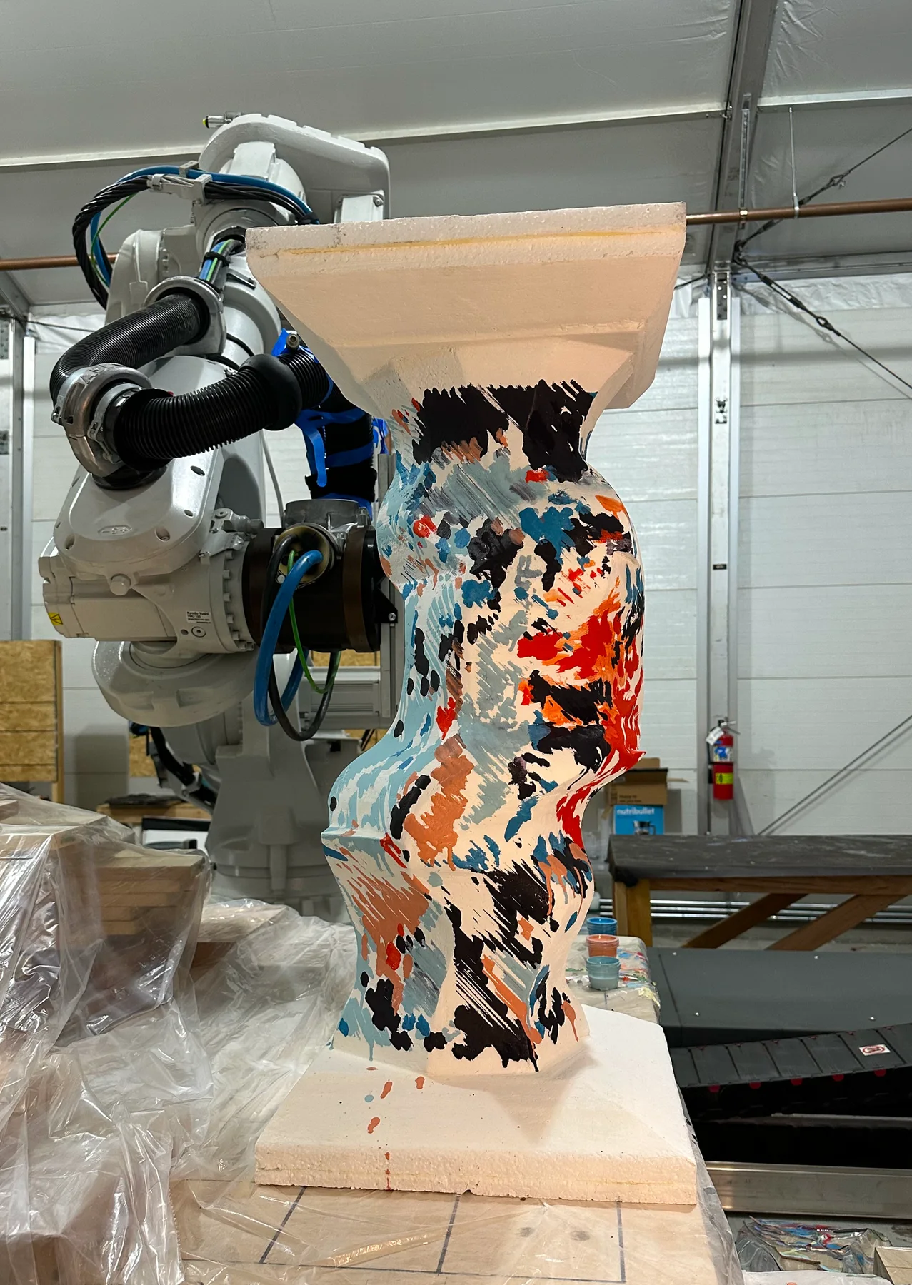 Robot arm beside a painted column